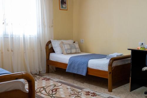 a bedroom with two beds and a window at Panoramic View House in Tepelenë