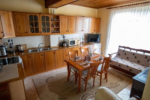 a kitchen with wooden cabinets and a table with chairs at Panoramic View House in Tepelenë