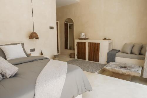 ein weißes Schlafzimmer mit einem Bett und einem Sofa in der Unterkunft Cahaya Villas - Luxury Villa With Private Pool in Gili Trawangan