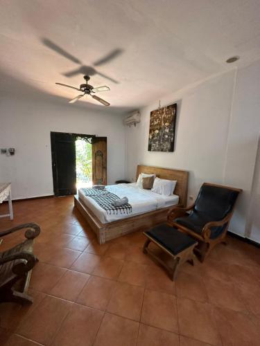 um quarto com uma cama e uma ventoinha de tecto em Diuma residence yoga meditation retreat and healing Center em Denpasar