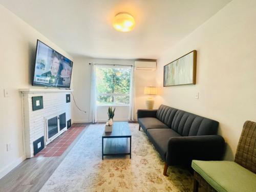 a living room with a couch and a fireplace at Super Privacy Lakeshore Forest Home with Air Conditioners at Haller Lake in Seattle