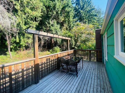 a deck with two chairs and a pergola at Super Privacy Lakeshore Forest Home with Air Conditioners at Haller Lake in Seattle
