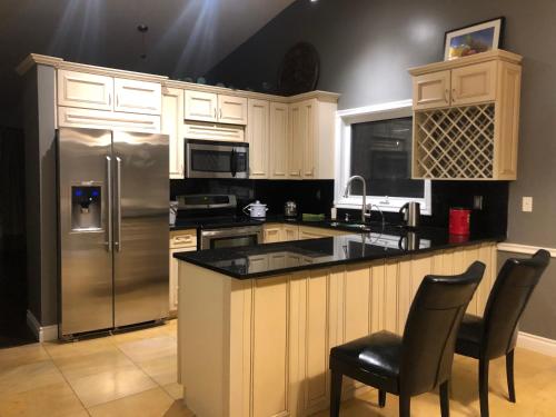 a kitchen with a stainless steel refrigerator and cabinets at citadel cozy quilt private bedroom in Calgary