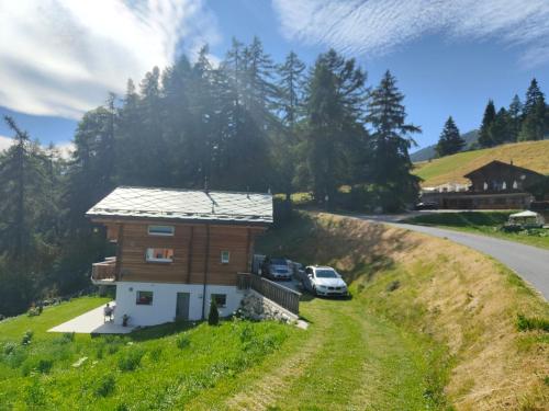 une petite maison sur une colline à côté d'une route dans l'établissement Chalet Matterhornsicht, à Naters