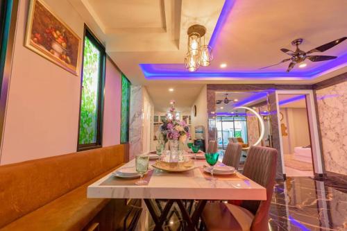Un comedor con una mesa con flores. en Ratsamee Poolvilla P, en Pattaya South
