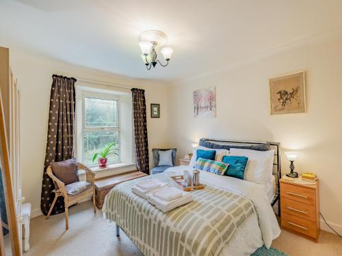 Cinderford的住宿－Oak Villa，卧室配有床、椅子和窗户。
