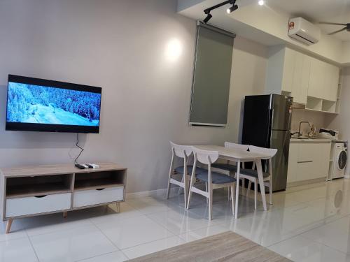 a kitchen with a table and a tv on the wall at Icon Residenz Icon City, Petaling Jaya by De Harlequins Guesthouse in Petaling Jaya