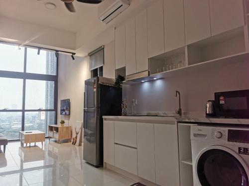 a kitchen with a washer and a dishwasher in it at Icon Residenz Icon City, Petaling Jaya by De Harlequins Guesthouse in Petaling Jaya