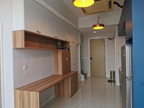 a large kitchen with wooden cabinets and a hallway at Icon Residenz Icon City, Petaling Jaya by De Harlequins Guesthouse in Petaling Jaya