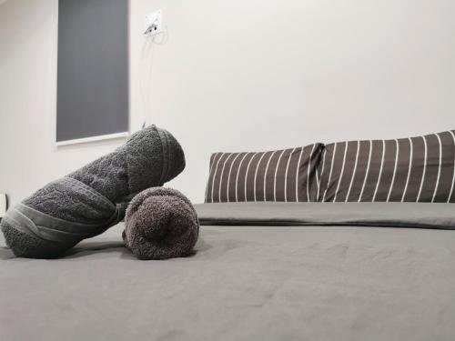 a stuffed teddy bear laying on a bed at Icon Residenz Icon City, Petaling Jaya by De Harlequins Guesthouse in Petaling Jaya