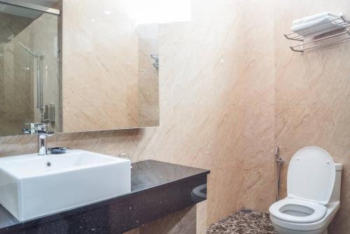 a bathroom with a sink and a toilet and a mirror at Hotel Pen Mutiara in Kampong Batu Maung