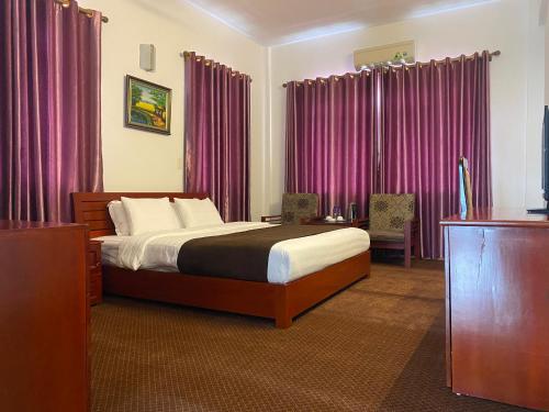 a bedroom with a bed with pink drapes at Bao Son Hotel in Ninh Lão