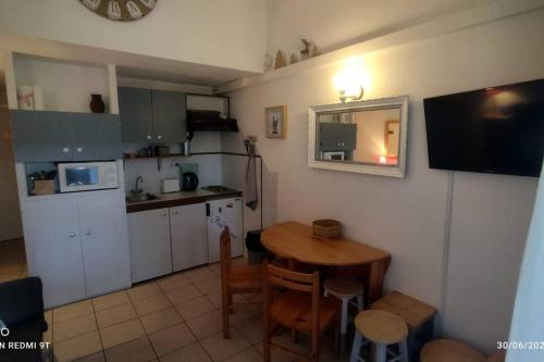 una pequeña cocina con una mesa pequeña y una pequeña cocina con mesa y sillas. en Petit chalet dans résidence en Font Romeu Odeillo Via