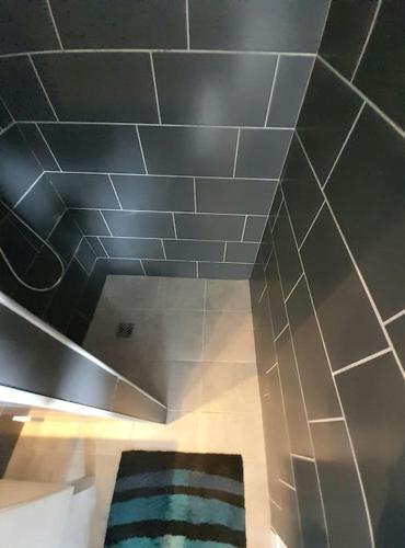 La salle de bains est pourvue de carrelage au plafond et d'un tapis. dans l'établissement Superbe loft 52 m2 où tout est accessible à pied, à Port-Vendres