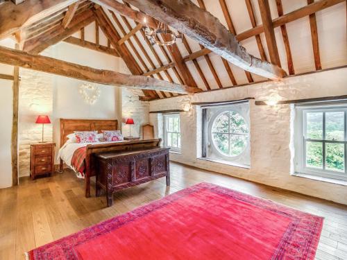 a bedroom with a bed with a desk and a red rug at The Coach House - Uk45027 in Gilwern