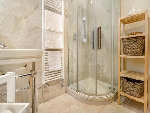 ein Bad mit einer Dusche und einem Waschbecken in der Unterkunft The Coach House - Uk45027 in Gilwern