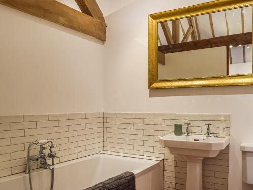 a bathroom with a bath tub and a sink at The Barn in Nantwich