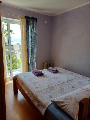a bedroom with a bed and a large window at Apartment Lina in Gradac