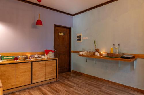 a kitchen with wooden cabinets and a counter top at Kamadhoo Inn in Baa Atoll