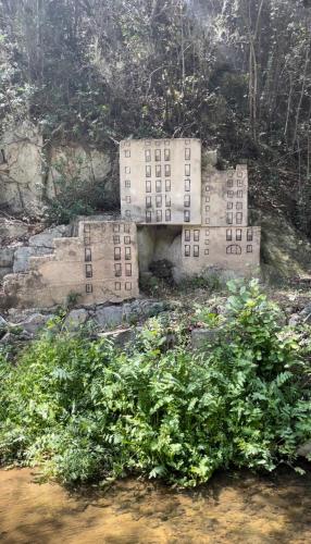 a building on the side of a hill with plants at Casa Rural para descansar piscina cerca in Osor