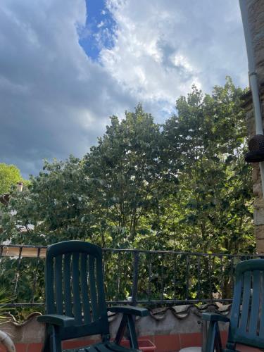 two green chairs sitting on a balcony with trees at Casa Rural para descansar piscina cerca in Osor