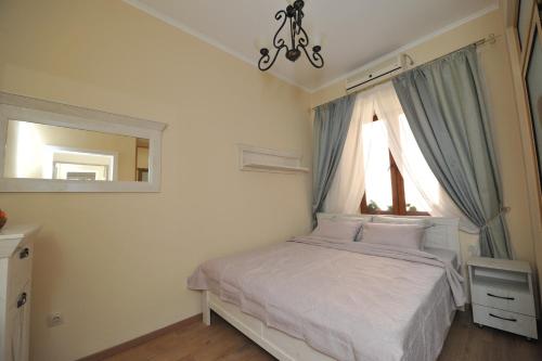Schlafzimmer mit einem Bett, einem Fenster und einem Spiegel in der Unterkunft BLISS HOUSE UNIRII in Oradea