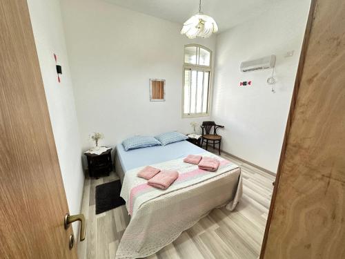 Un dormitorio con una cama con toallas rosas. en EMAN SWEET HOME - cozy privet unique apartment in haifa downtown, en Haifa