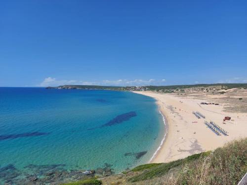 a view of a beach with chairs and people on it at Sulla via del Mare Room I.U.N R5045 in Terralba