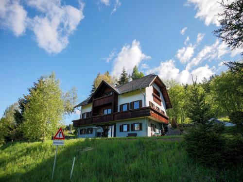 a house sitting on top of a grassy hill at Apartment in Fresach near Millstättersee with pool in Fresach