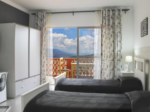 1 dormitorio con 2 camas y ventana grande en 5 Swiss Hotel en Kigali