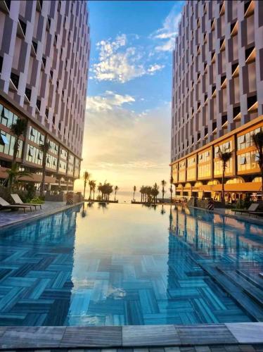 a large swimming pool in the middle of two buildings at Bstudio in APEC Mandala Mũi Né in Phan Thiet