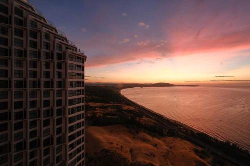 a view of a building and the ocean at sunset at Bstudio in APEC Mandala Mũi Né in Phan Thiet