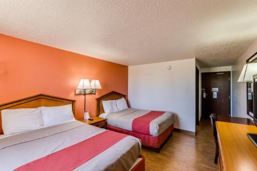 a hotel room with two beds and a desk at Motel 6-Albert Lea, MN in Albert Lea