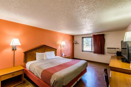um quarto de hotel com uma cama, uma secretária e uma televisão em Motel 6-Albert Lea, MN em Albert Lea