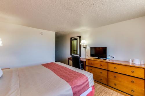 a bedroom with a bed and a dresser with a television at Motel 6-Albert Lea, MN in Albert Lea
