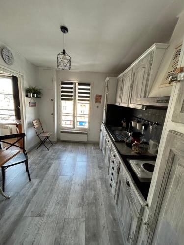 une cuisine avec des armoires blanches et un plancher en bois dans l'établissement Plage port tout à pied, à Dieppe