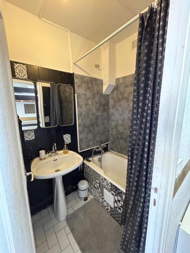 La salle de bains est pourvue d'un lavabo, d'une baignoire et de toilettes. dans l'établissement Plage port tout à pied, à Dieppe