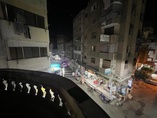 vistas a una calle de la ciudad por la noche con edificios en غرفه واحده فقط داخل شقه بها سرير ١٢٠ سم ومروحه ودولاب وكراسي en El Mansurá