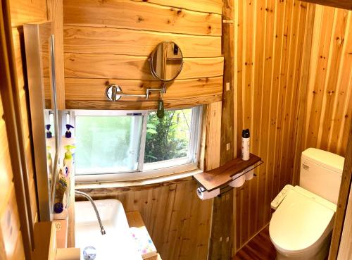 een kleine badkamer met een toilet en een raam bij 一棟貸しの移住案内古民家　itoma in Setouchi