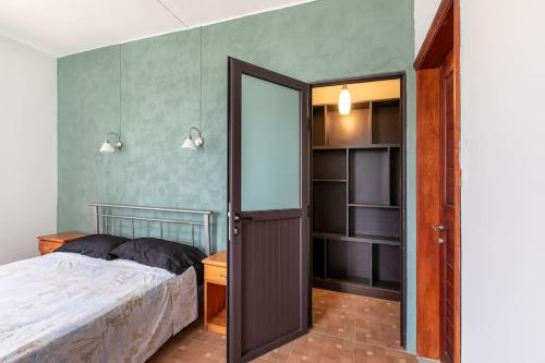 a bedroom with a bed and an open door at Spacious and Cosy Coastal Retreat in Albion