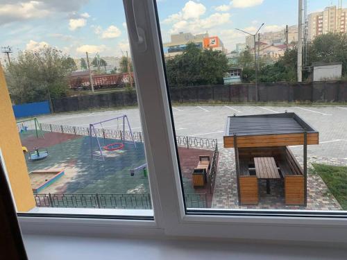 una ventana con vistas a un parque infantil en Dream town Apartaments біля залізничного вокзалу en Lutsʼk