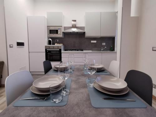 a kitchen with a table with plates and wine glasses at Casa Crisale in Alba