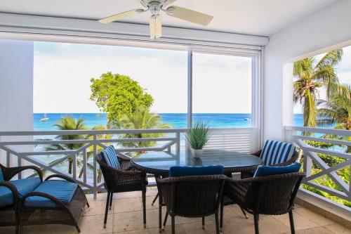 a dining room with a table and chairs and a view of the ocean at Waterside 306 apts in Saint James