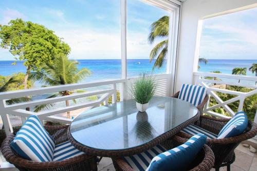 una mesa y sillas en un balcón con vistas al océano en Waterside 306 apts, en Saint James