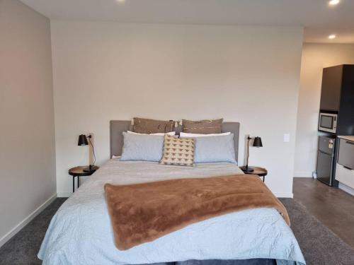 um quarto com uma cama grande e 2 mesas de cabeceira em Guest House on Sapphire em Wanaka