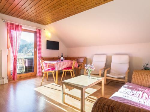 Comfortable Apartment in Thomatal near Ski Area في Thomatal: غرفة معيشة مع طاولة وكراسي