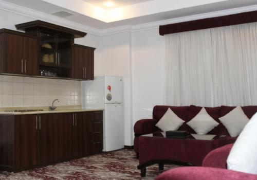 a living room with a couch and a kitchen at Carawan Al Khaleej Hotel Olaya in Riyadh