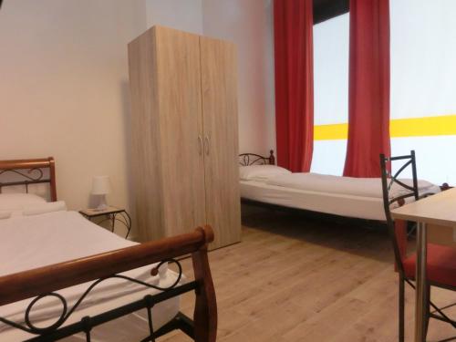 a bedroom with two beds and a wooden cabinet at Pension Stadtpark in Hamburg
