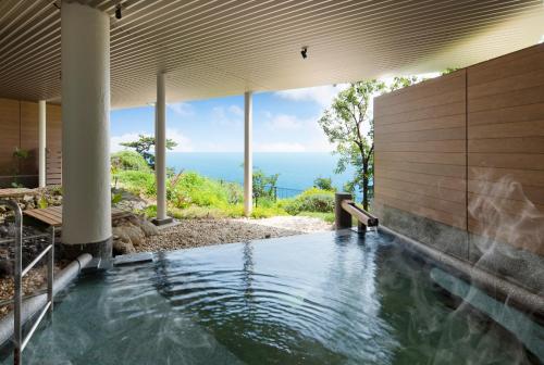 an infinity pool in a house with the ocean in the background at 焼津グランドホテル in Hanazawa