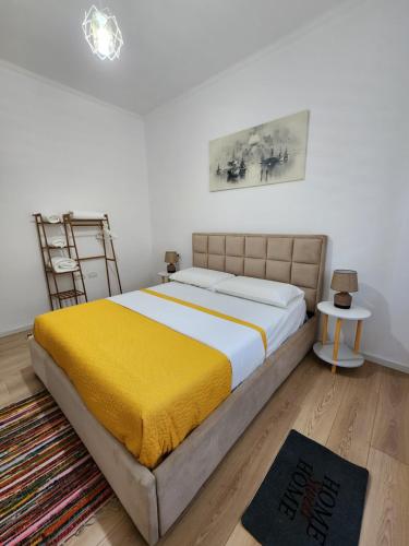a bedroom with a large bed with a yellow blanket at Apartment Sweet 21 in Tirana